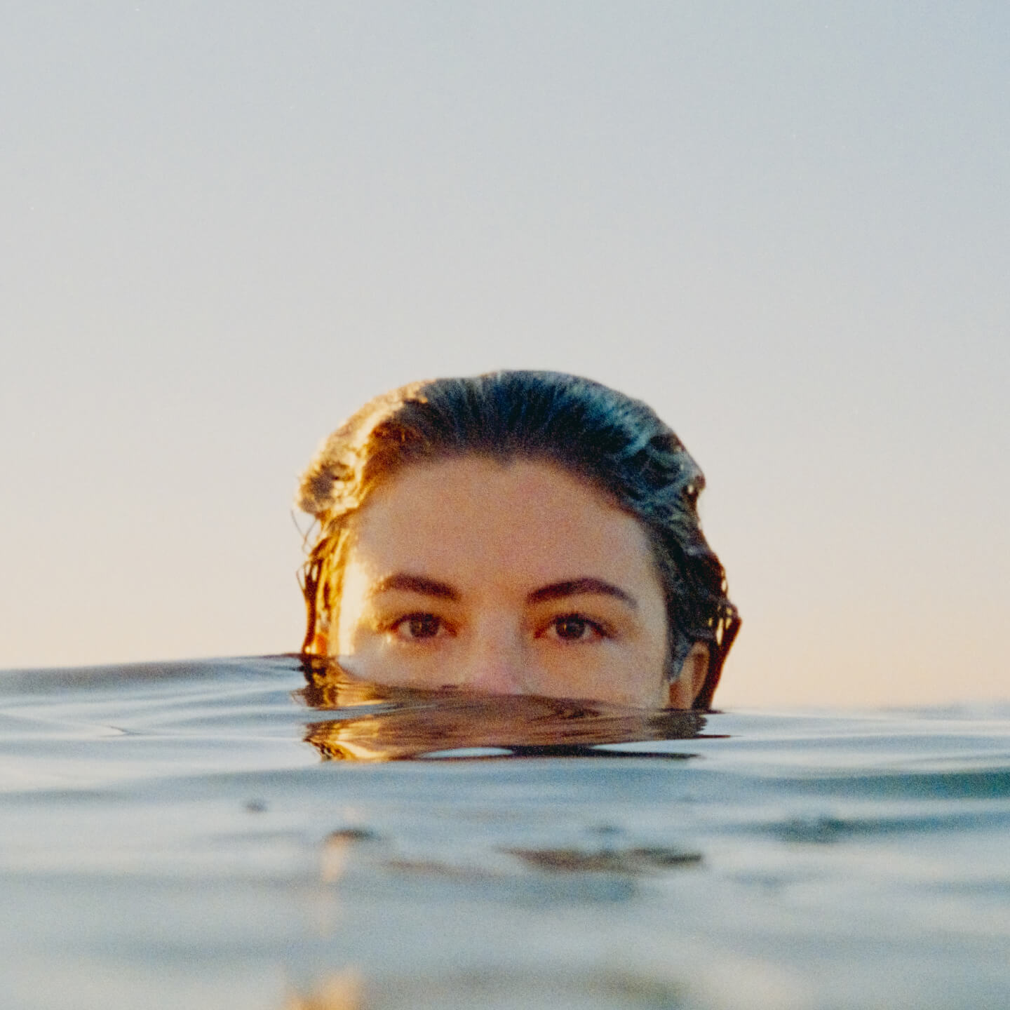 A swimmer peeking out from waves in the ocean