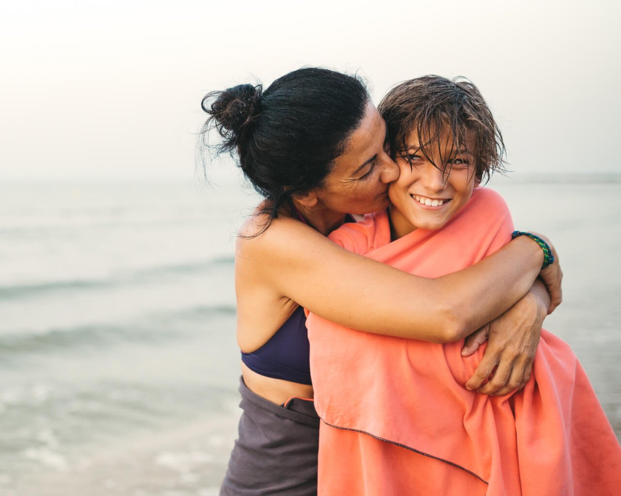 A mother having a swim in the ocean with her son.