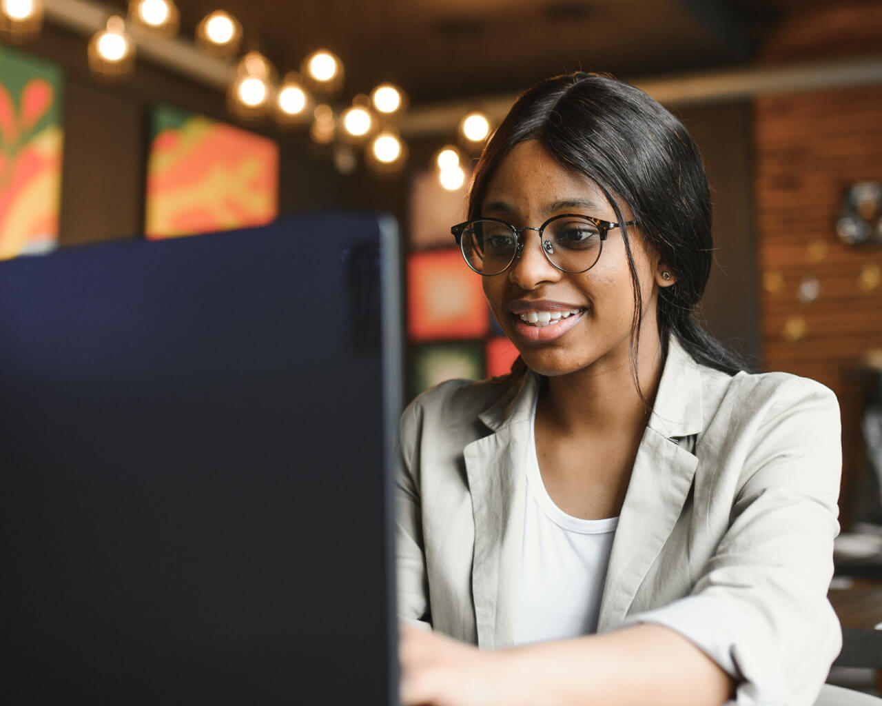 A young business professional looking up investments information on her laptop.