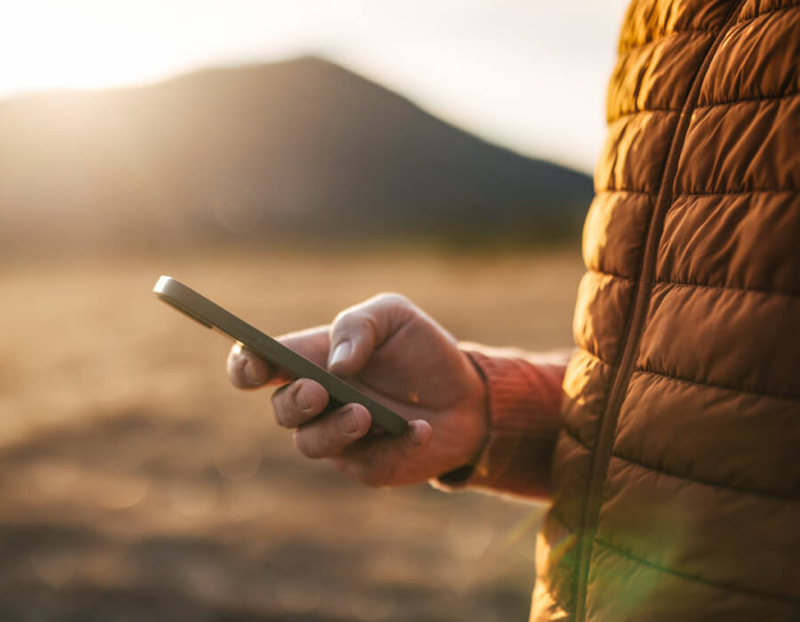 Man's hand outside looking at mobile