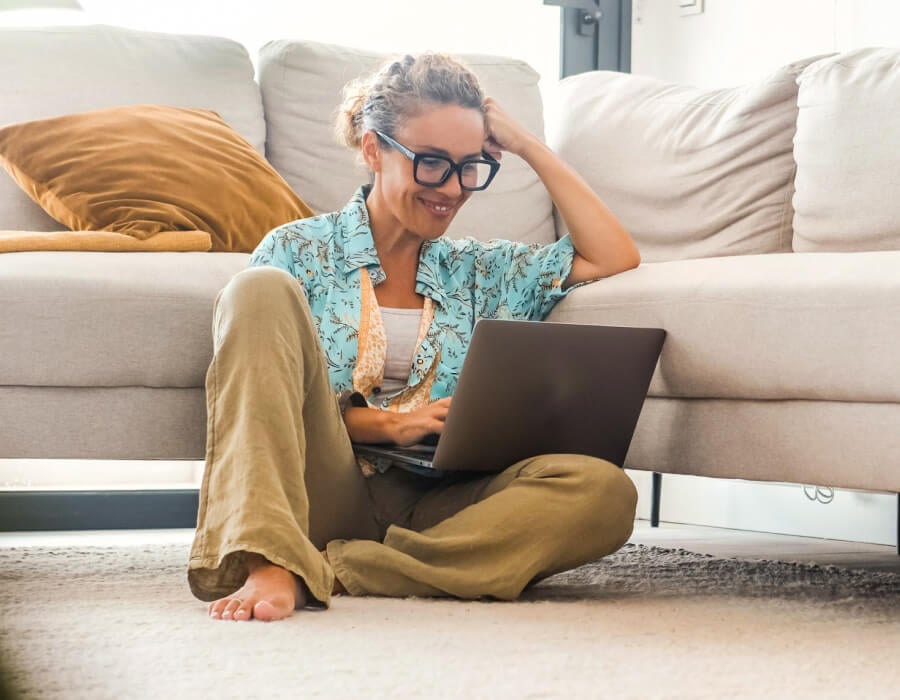 Woman sitting on floor working on laptop