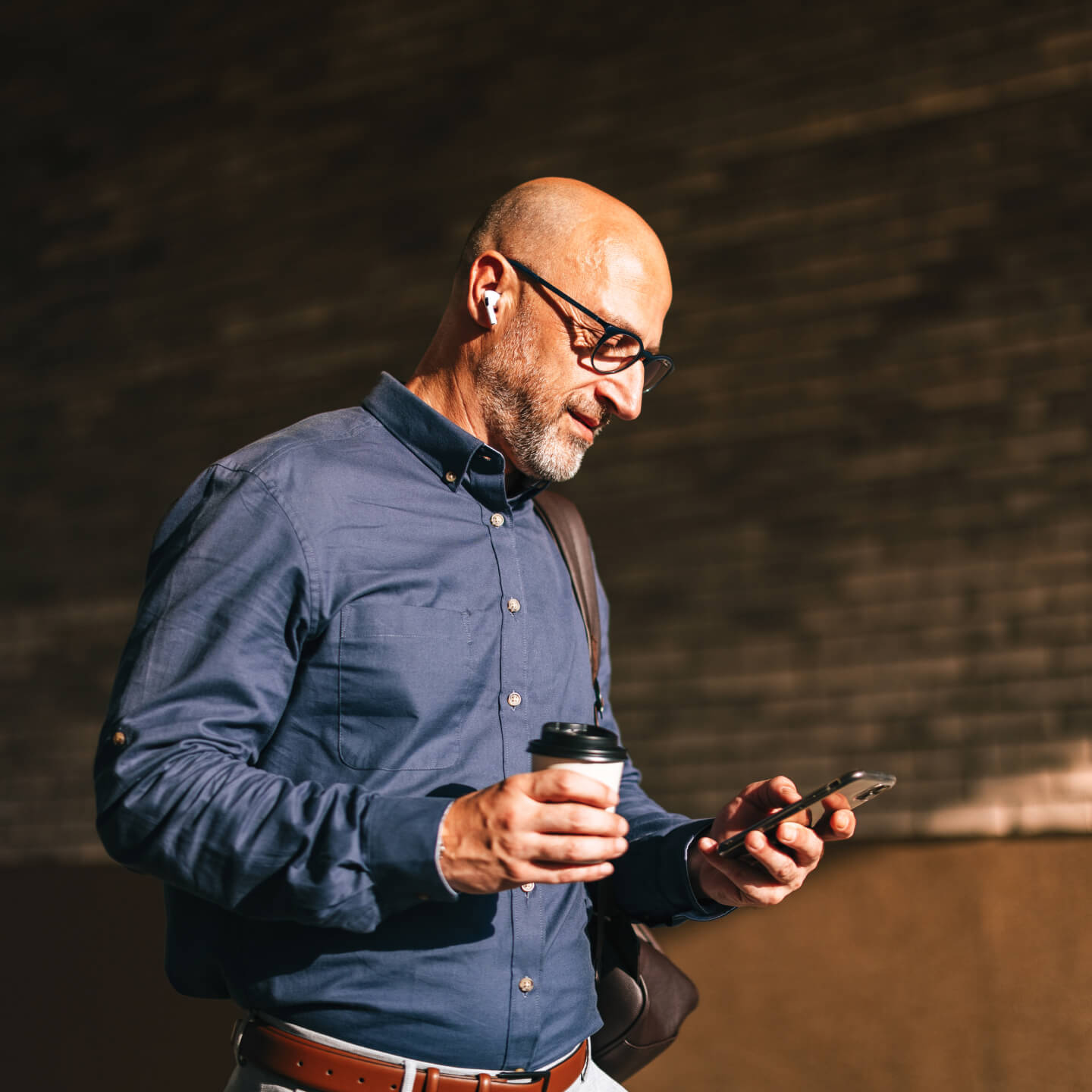 Man walking outside looking at phone