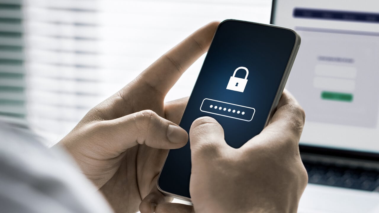 A man entering a password on his mobile phone.