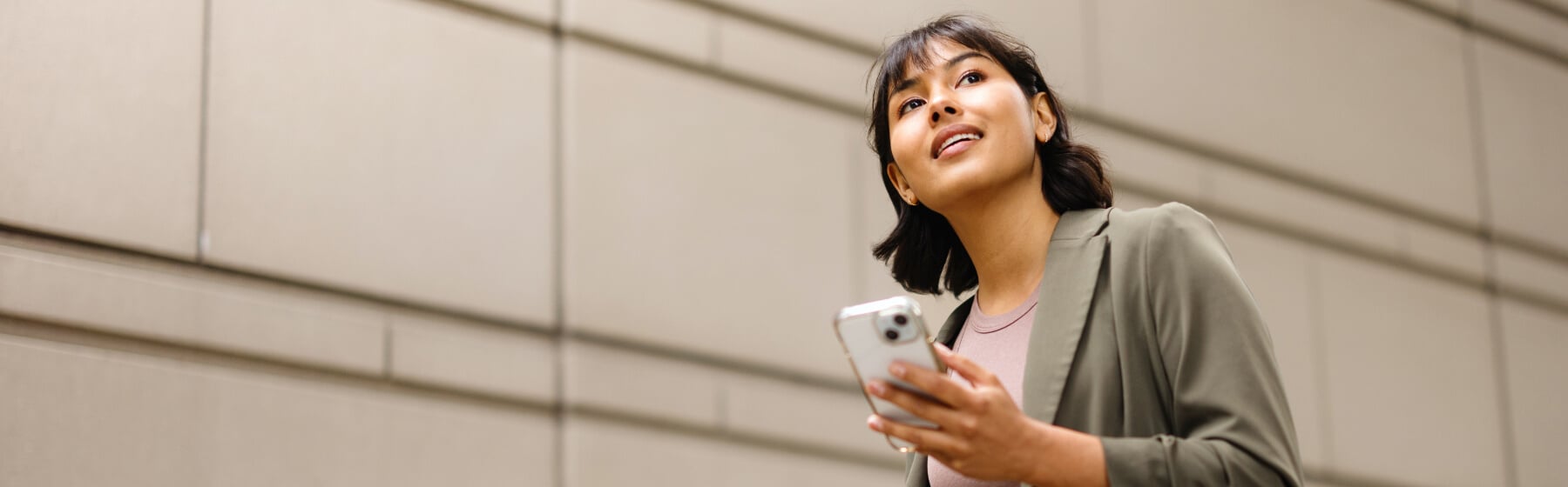 A woman walking and looking at her phone.