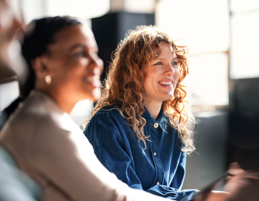 News and Insights Two office workers looking up news on their laptops.