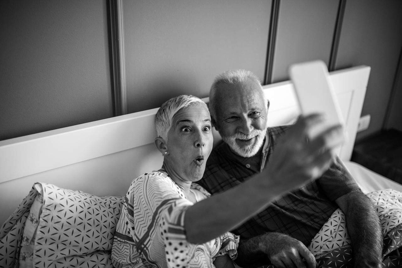 A senior couple is making funny faces while taking a photo for their loved ones.