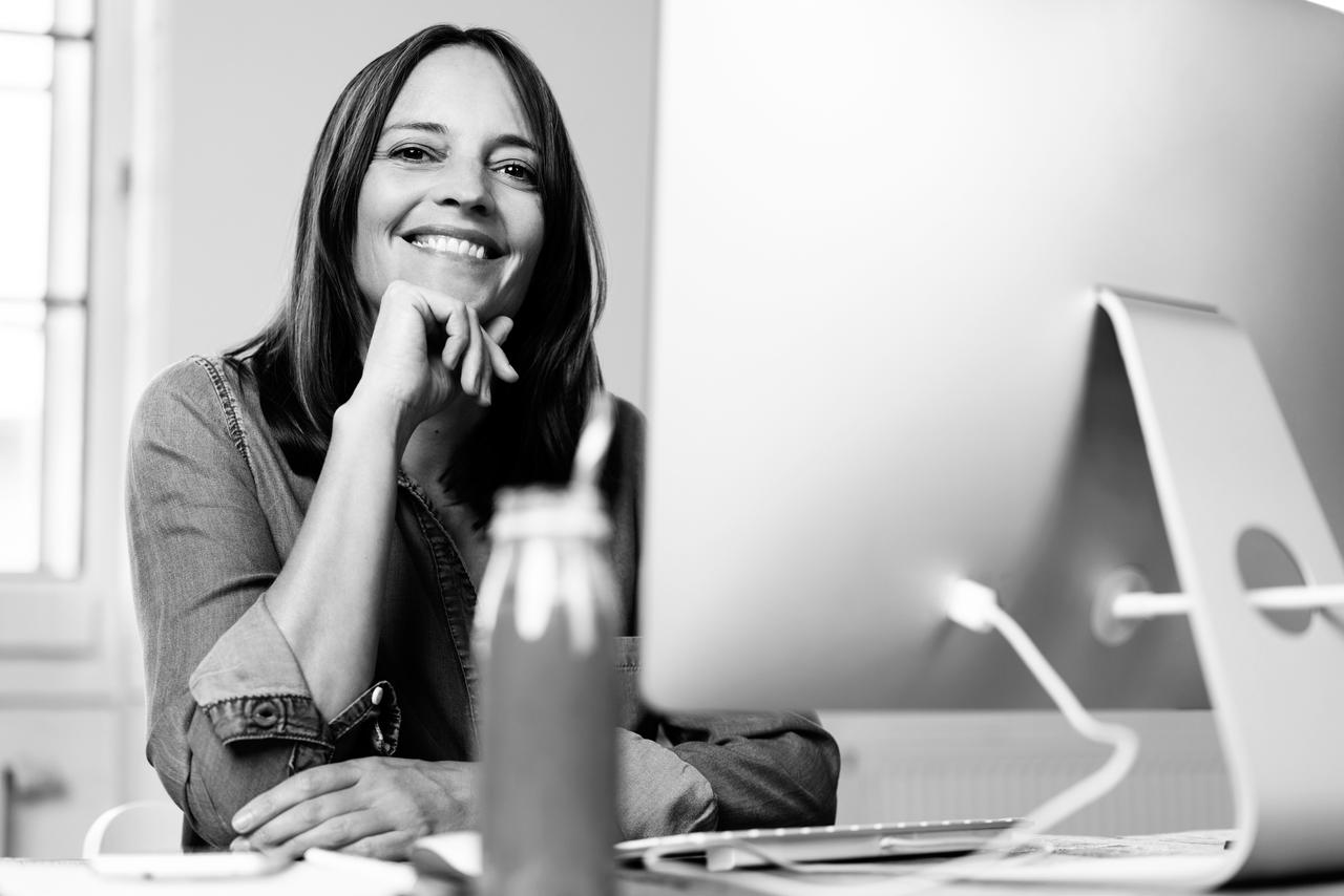 A woman smiling at a computer