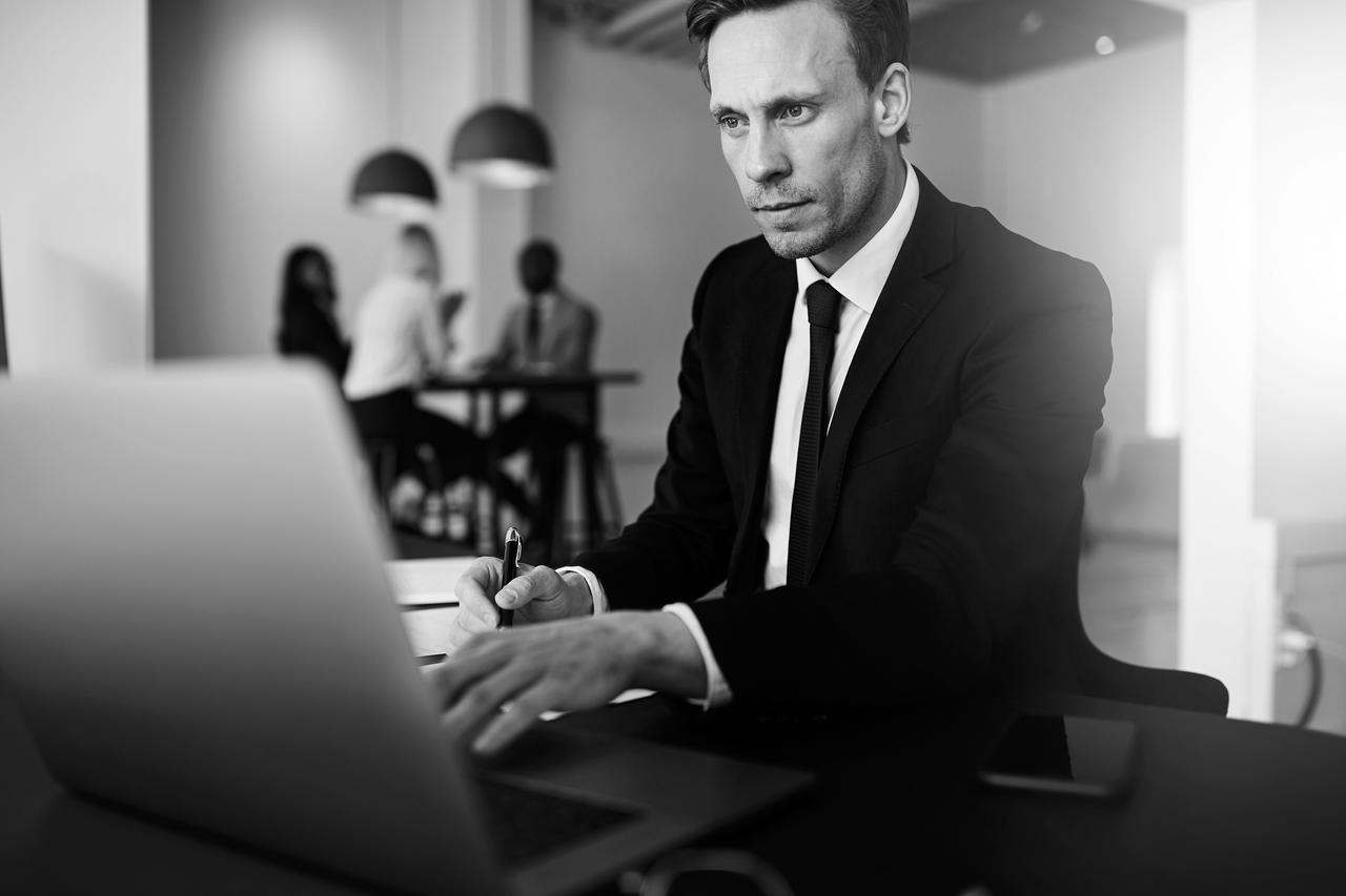 Businessman working on a laptop while sitting at his desk