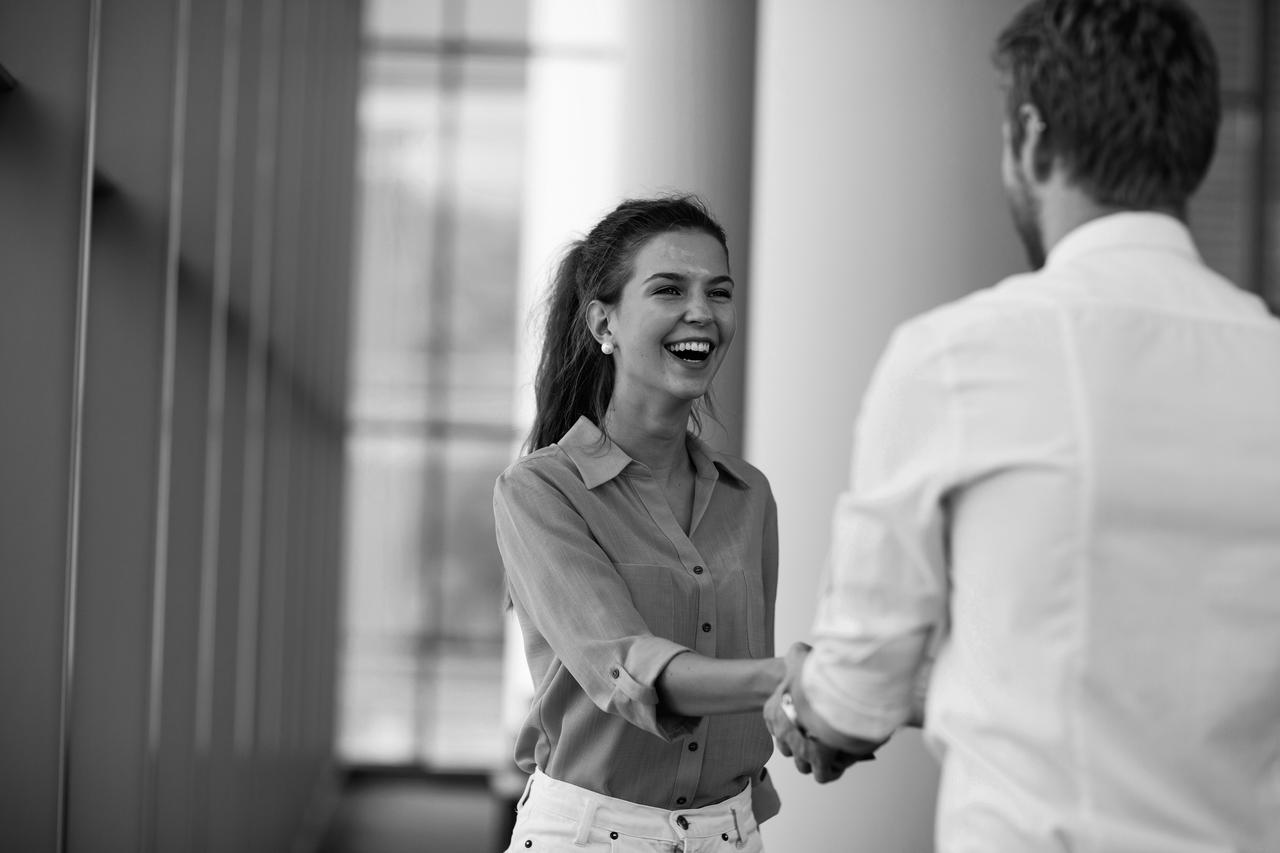 A young woman and man shaking hands