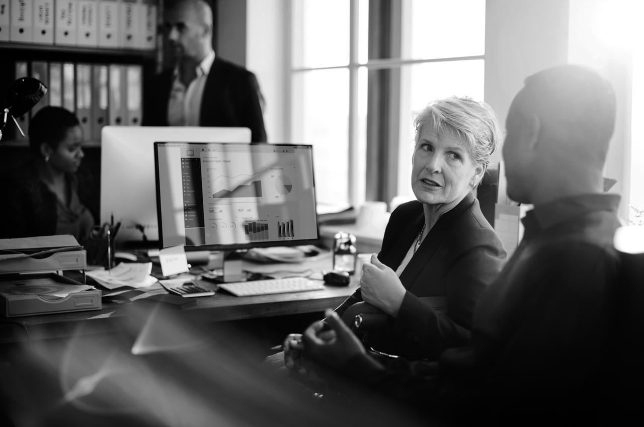 A woman and man in an office setting having a conversation