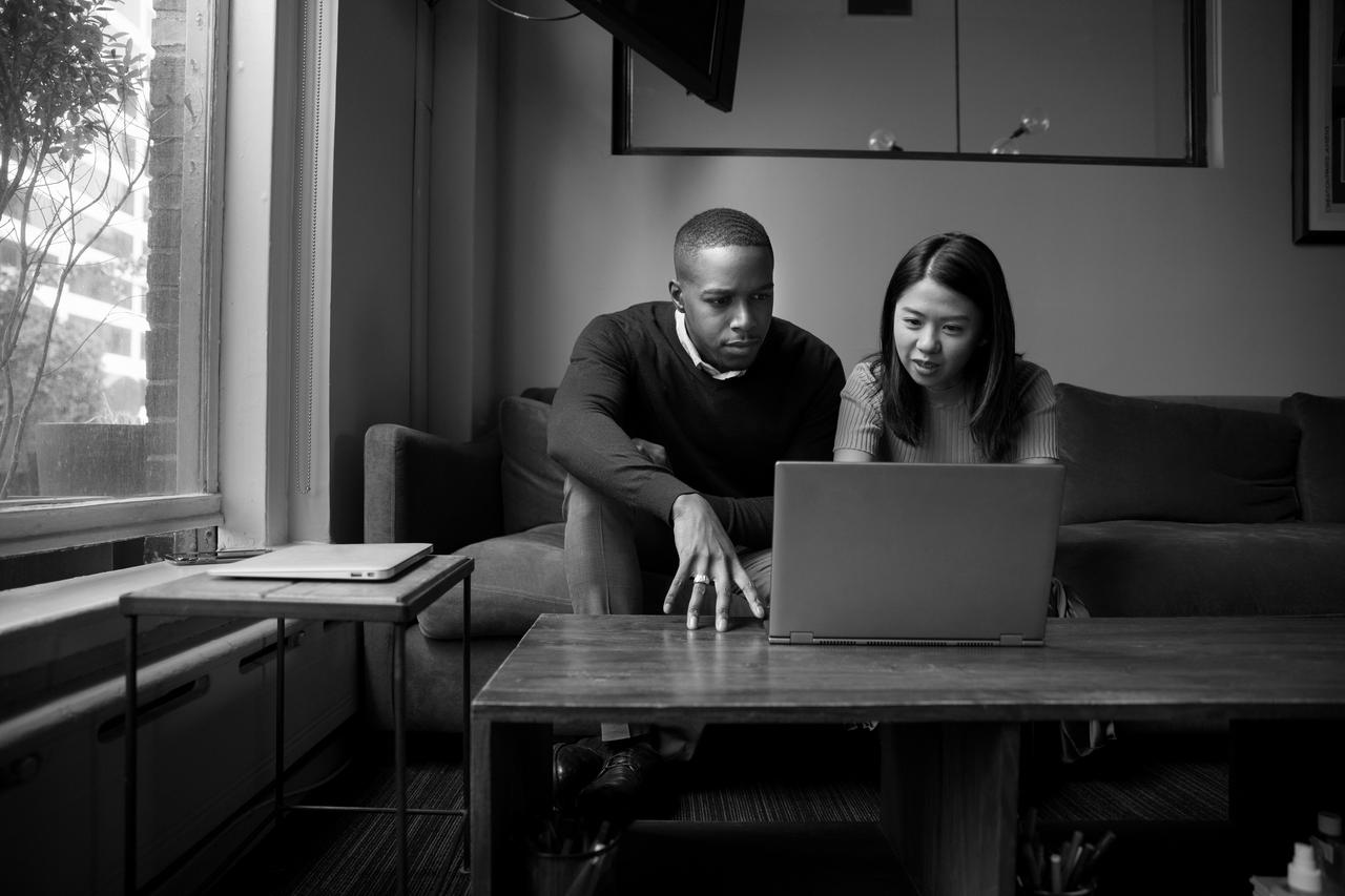 A man and woman looking at a laptop