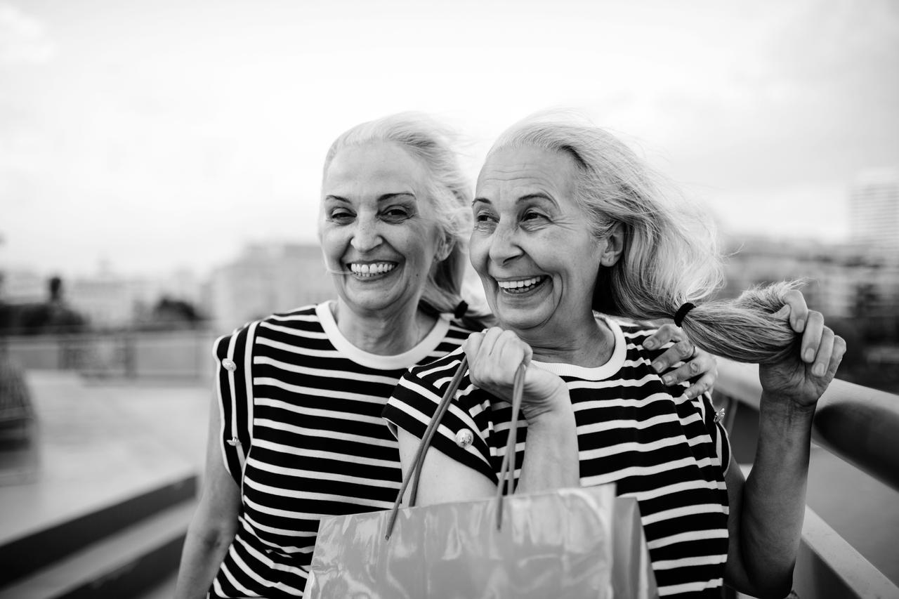 Happy senior ladies dressed in same clothes walking in the city.