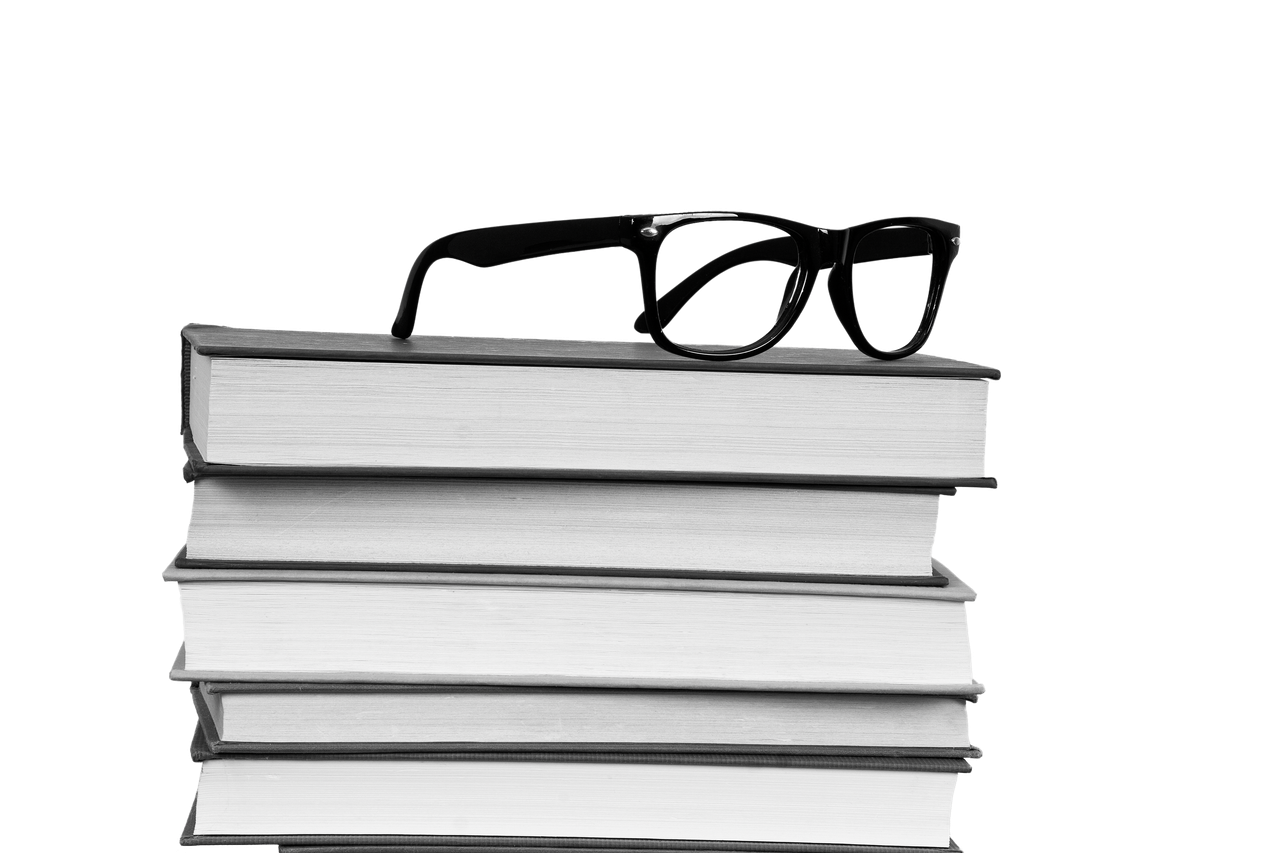 A pair of glasses sitting on a stack of books
