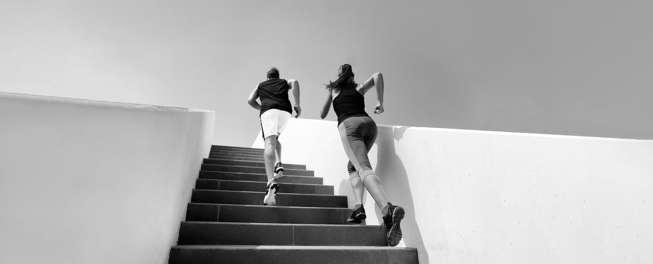 Two people running up a stair case outside