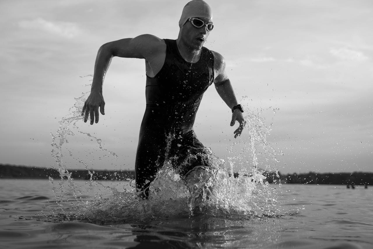 The triathlete runs out of the water during swim training