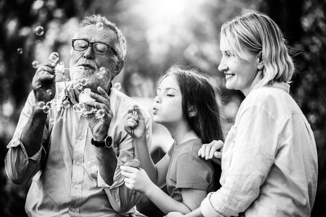 Happy family blows soap bubbles together