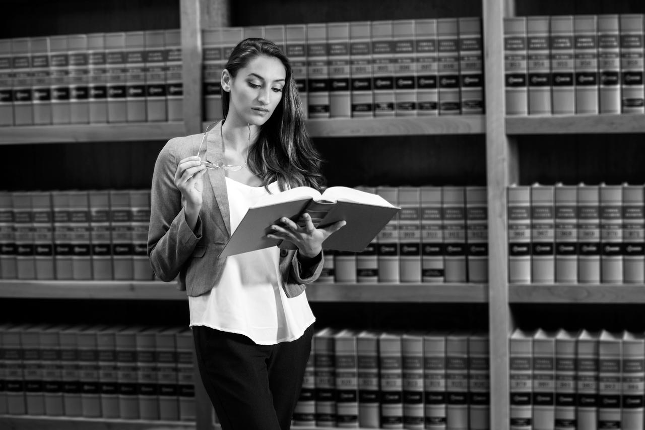 A woman reading a book in a library