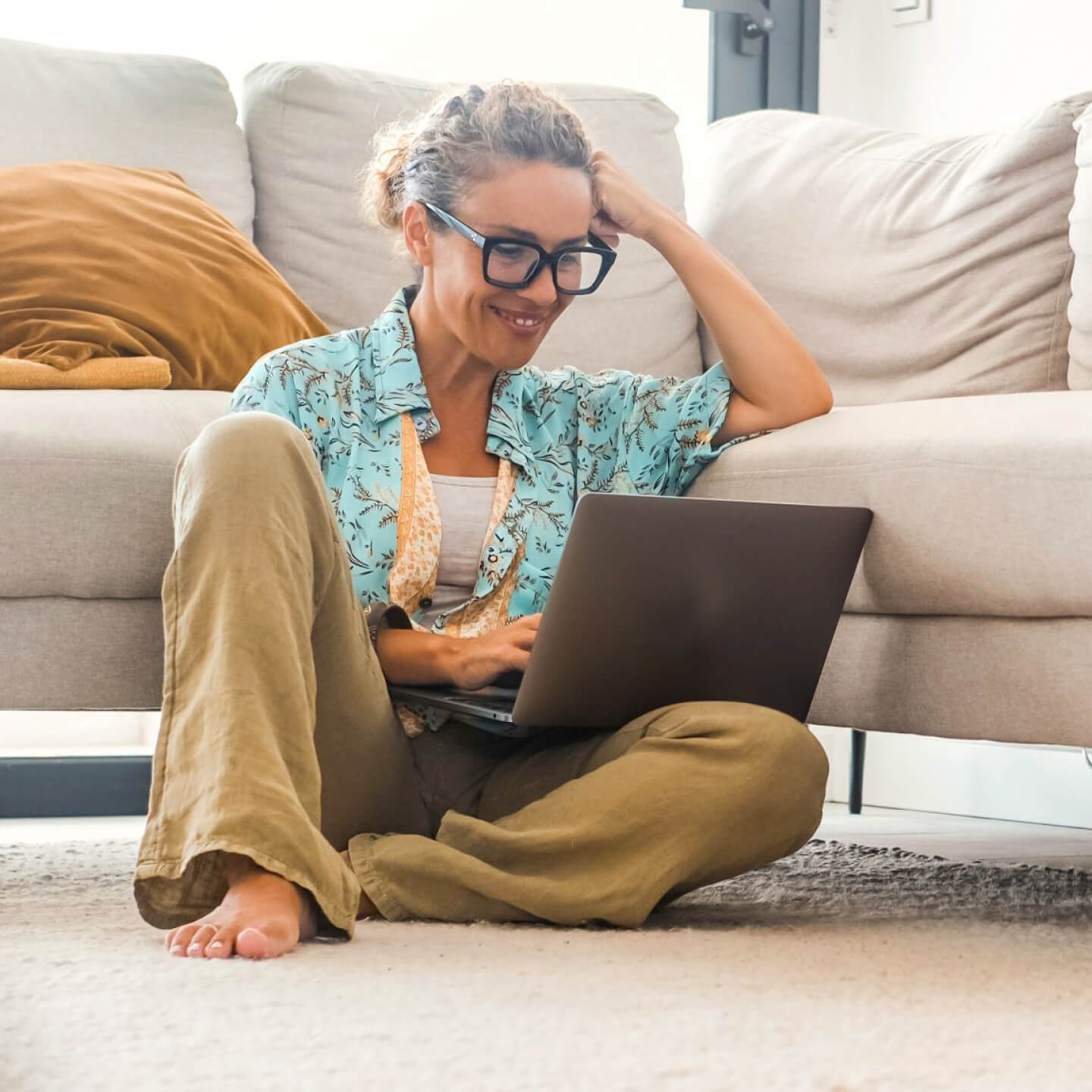 Woman sitting on floor working on laptop