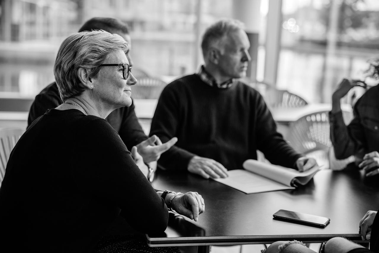 Senior businesswoman in a meeting surrounded by group of business people Senior businesswoman sitting in boardroom meeting.